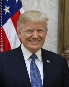 President Donald Trump poses for his official portrait at The White House, in Washington, D.C., on Friday, October 6, 2017. (Official White House Photo by Shealah Craighead), Public Domain.